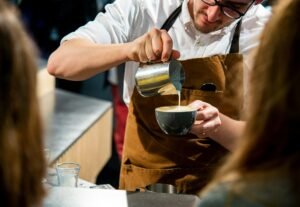 A professional barista using high-quality tools to brew coffee in a specialty café in Iran.