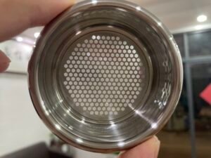 Precision engineered stainless steel coffee basket with uniform perforation pattern