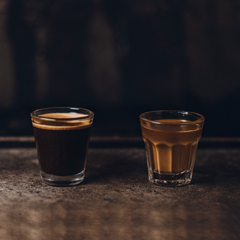 Side-by-side: A shot of espresso with crema and a cup of clear pour-over coffee