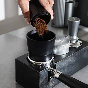 Professional barista using a portafilter funnel while preparing espresso