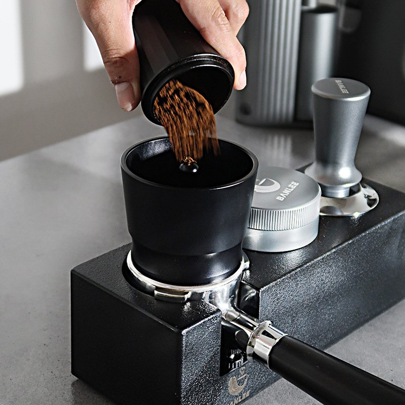 Portafilter funnel with coffee grounds being added to espresso basket