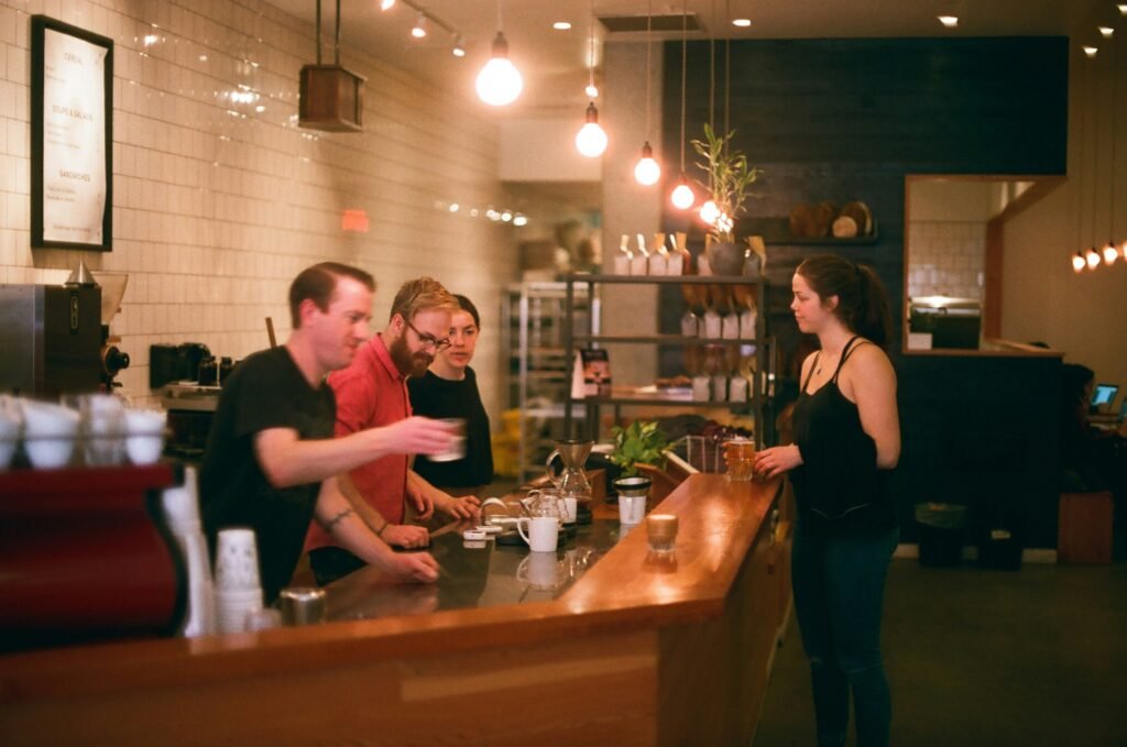 alt text: A person adjusting their coffee grinder next to a V60 setup