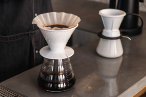Barista demonstrating techniques to pour two cups of coffee simultaneously