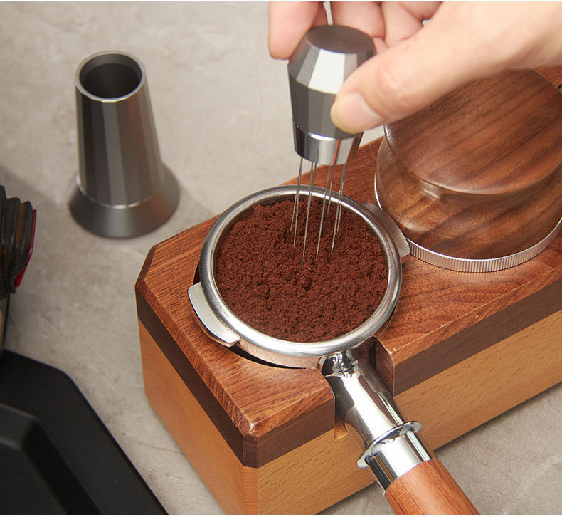 Barista using WDT tool to distribute coffee grounds evenly in espresso portafilter